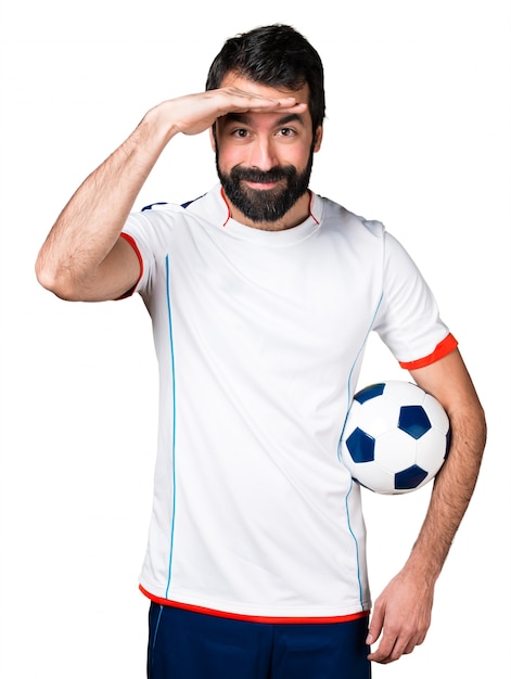 Gratis foto voetballer met een voetbal die iets laat zien