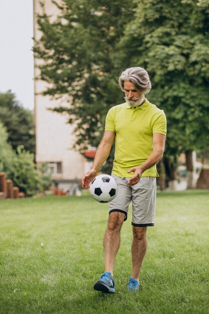 Voetballer van middelbare leeftijd met voetbalbal