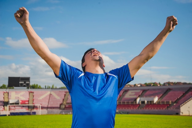 Gratis foto voetbalspeler die overwinning viert