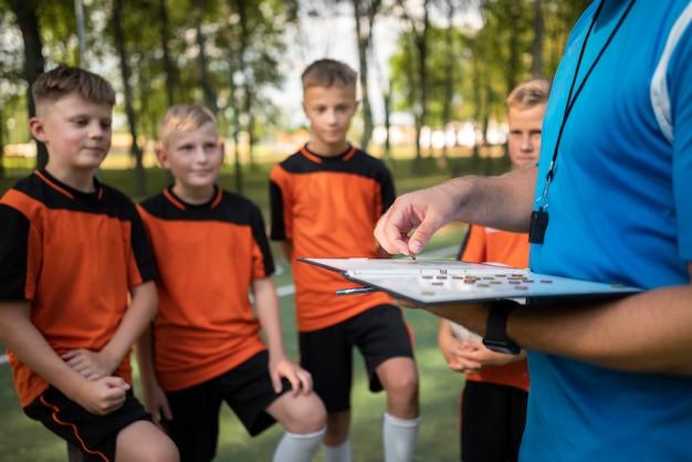 Gratis foto voetbaltrainer die zijn leerlingen lesgeeft