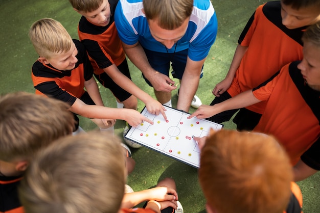 Voetbaltrainer die zijn leerlingen lesgeeft