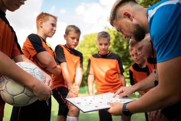 Voetbaltrainer die zijn leerlingen lesgeeft