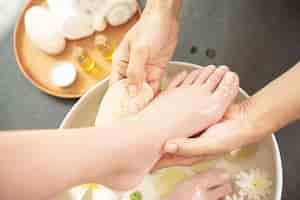 Gratis foto voeten wassen in spa voor behandeling. kuur en product voor vrouwelijke voeten en handkuuroord.