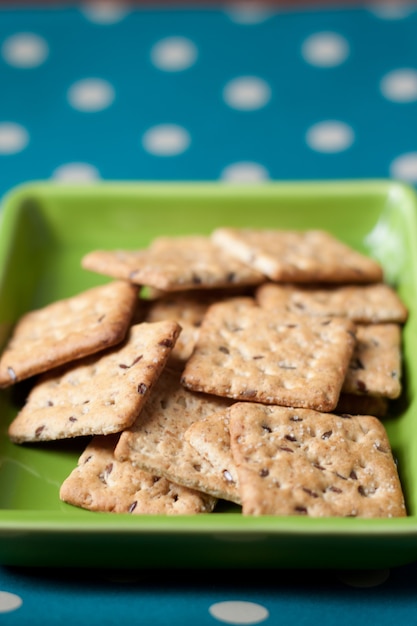 Volkoren koekjes op een groene plaat en stippenbord