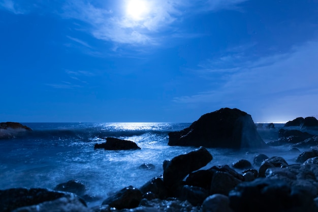 Volle maan aan de hemel boven zeewater