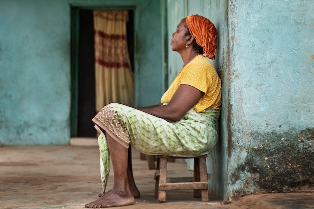 Volledig geschoten Afrikaanse vrouw zittend op een stoel