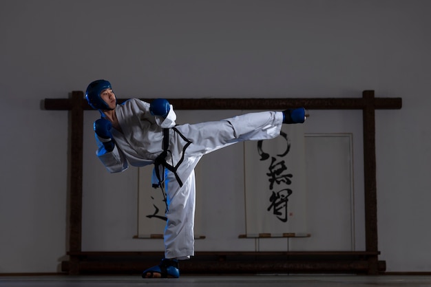 Volledig geschoten Aziatische man die taekwondo beoefent