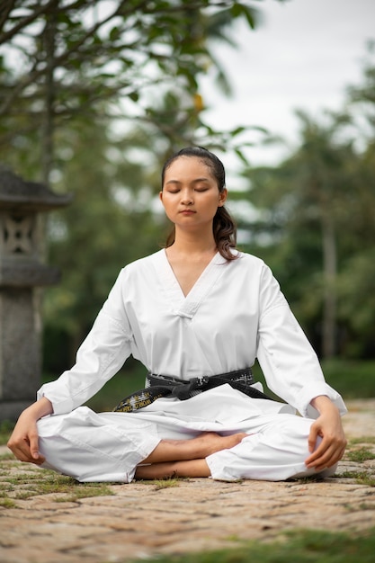 Volledig geschoten Aziatische vrouw die taekwondo beoefent