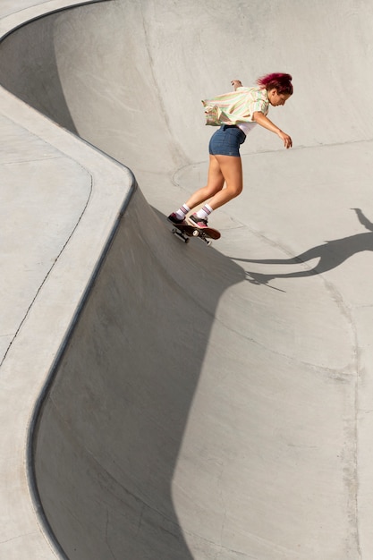 Gratis foto volledig geschoten coole vrouw die plezier heeft op skateboard