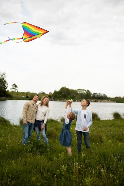 Volledig geschoten gelukkige familie vliegende regenboogvlieger