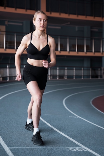 Volledig geschoten geschikte vrouw die bij gymnastiek loopt