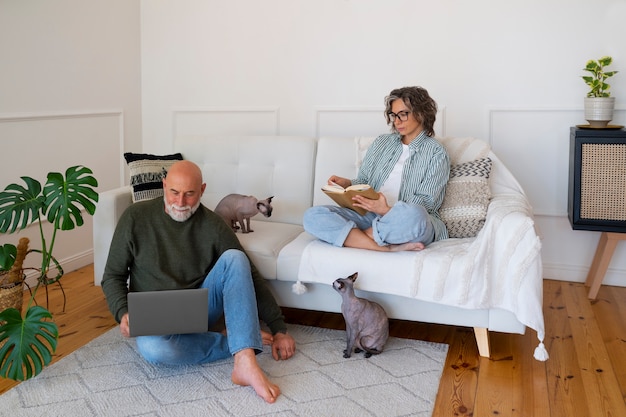 Gratis foto volledig geschoten hoger paar met kat thuis