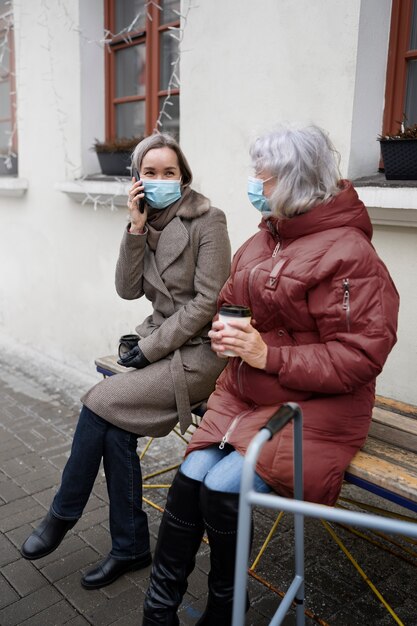 Volledig geschoten hogere vrouwen die op bank zitten