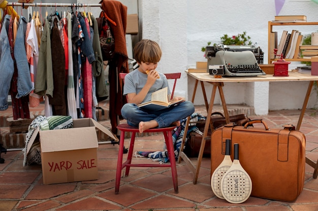 Gratis foto volledig geschoten jongen bij garage sale