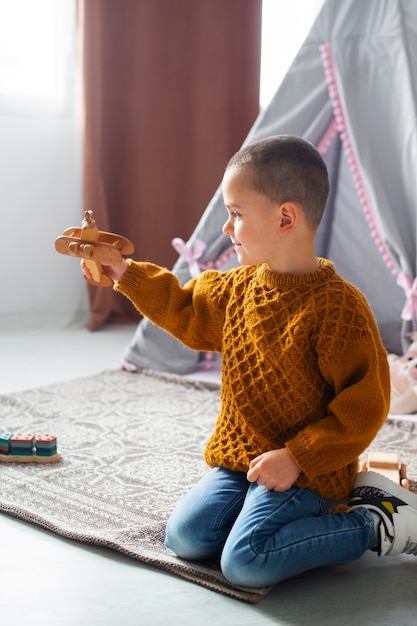 Gratis foto volledig geschoten jongen die thuis speelt