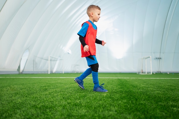 Gratis foto volledig geschoten kind op voetbalveld