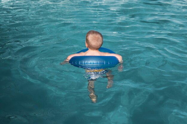 Volledig geschoten kind zwemmen met reddingsboei