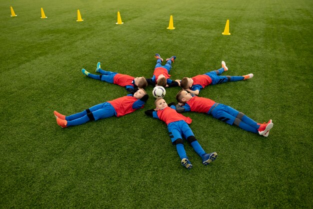 Volledig geschoten kinderen die op gras leggen