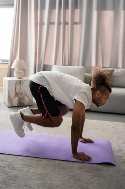 Volledig geschoten man die op yogamat uitoefent