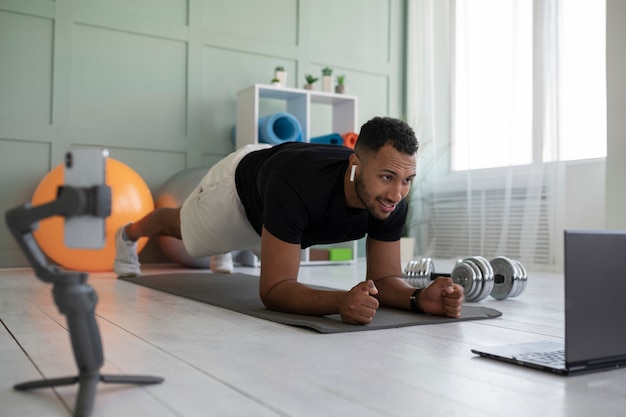 Gratis foto volledig geschoten man die plank doet