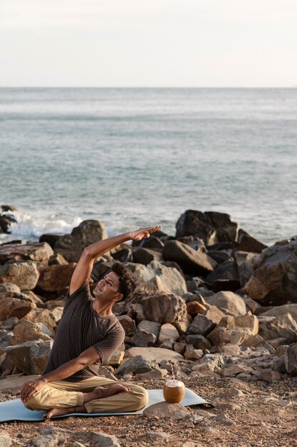 Volledig geschoten man die yoga doet op mat