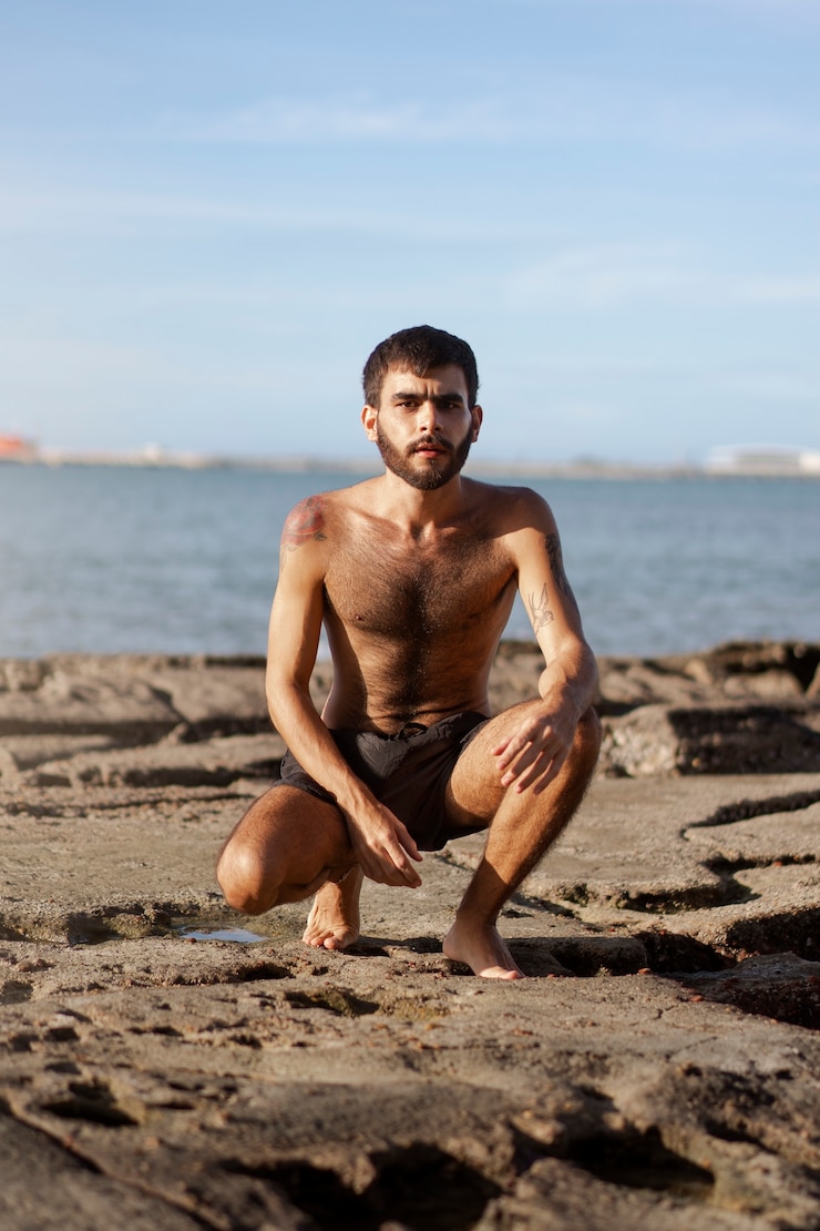 Gratis Foto volledig geschoten man met harige borst aan zee