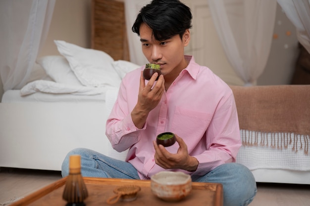 Gratis foto volledig geschoten man met matcha-thee