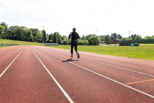 Volledig geschoten man met prothese die buiten loopt