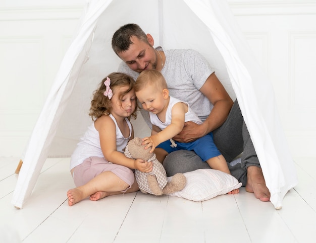 Volledig geschoten man spelen met kinderen in een tent