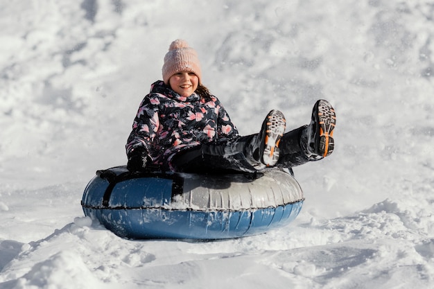 Gratis foto volledig geschoten meisje dat in sneeuw speelt