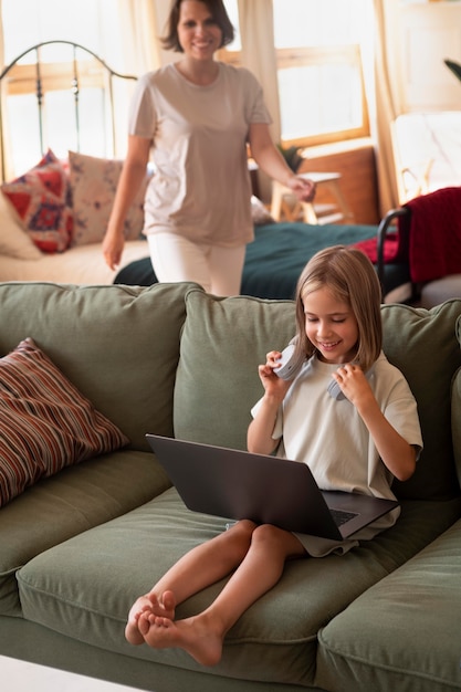 Gratis foto volledig geschoten meisje met laptop en koptelefoon