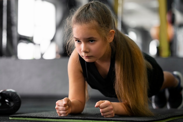 Gratis foto volledig geschoten meisje traint in de sportschool