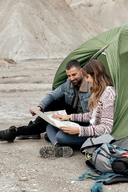 Volledig geschoten mensen met kaart op zand