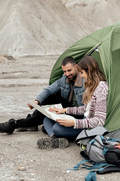 Volledig geschoten mensen met kaart op zand