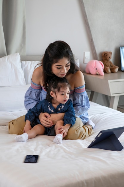 Volledig geschoten moeder en meisje die tablet bekijken