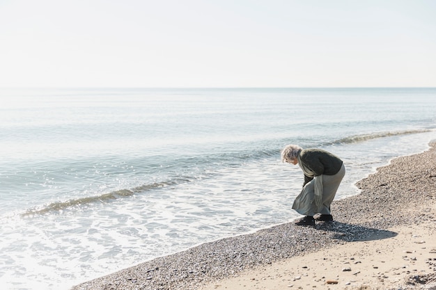 Volledig geschoten oude vrouw in de buurt van de zee