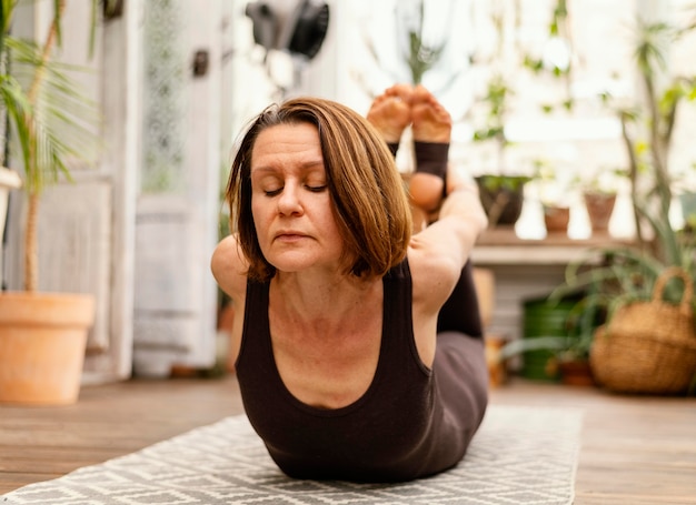 Gratis foto volledig geschoten oude vrouw op yogamat