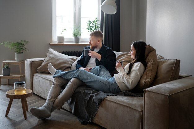 Volledig geschoten paar zittend op de bank