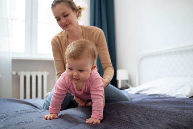 Volledig geschoten schattige baby die leert kruipen