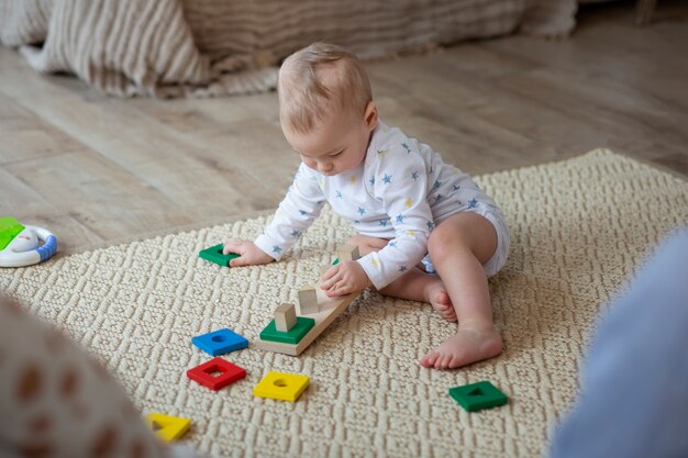 Volledig geschoten schattige baby die op de vloer speelt