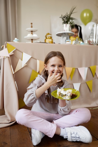 Volledig geschoten smileymeisje met cake