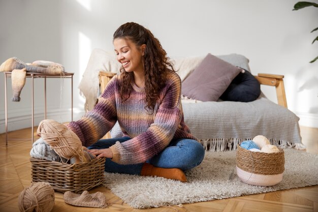 Volledig geschoten smileyvrouw die op vloer zit