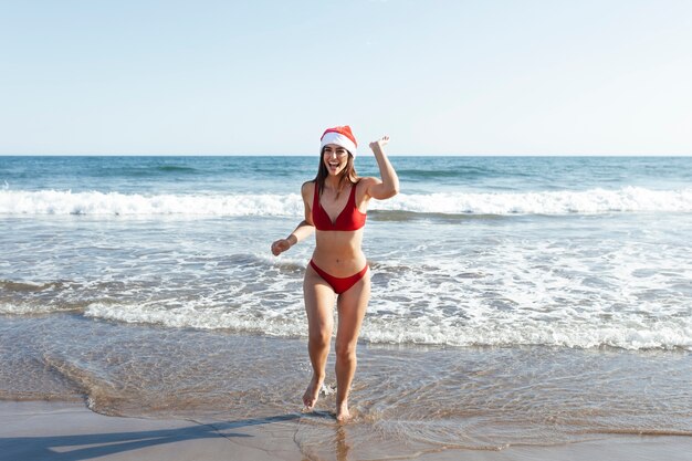 Volledig geschoten smileyvrouw met kerstmuts