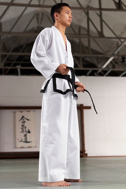 Gratis foto volledig geschoten tiener die taekwondo beoefent