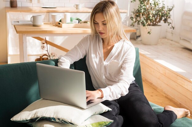 Volledig geschoten vrouw bij het werken op de bank