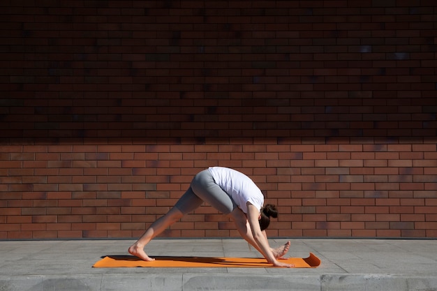 Volledig geschoten vrouw die buiten yoga doet