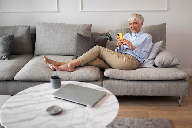 Volledig geschoten vrouw die een pauze neemt met smartphone