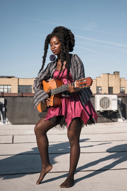 Gratis foto volledig geschoten vrouw die gitaar speelt