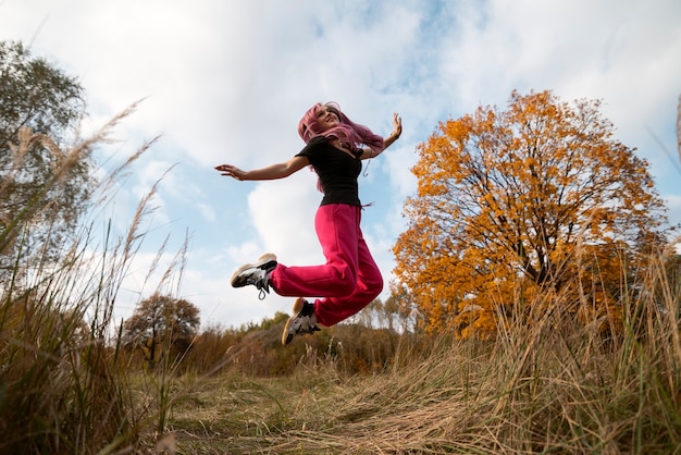 Gratis foto volledig geschoten vrouw die in de natuur springt