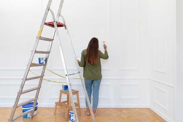 Gratis foto volledig geschoten vrouw die muur schildert